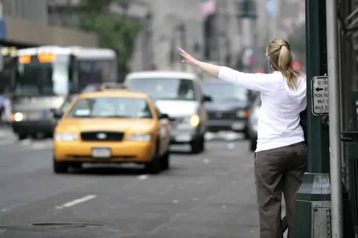 a woman hails a taxi